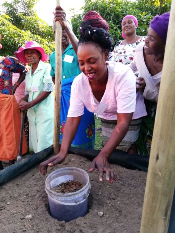 Woman planting a bucket with small rocks in