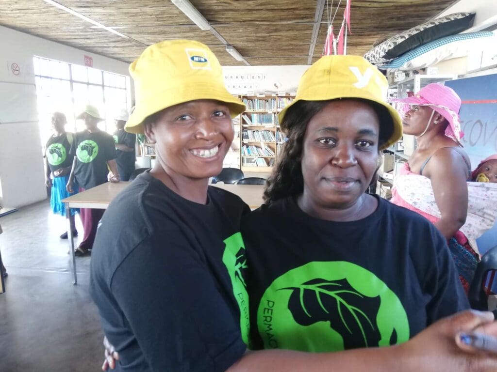 Two woman with yellow MTN hats on