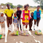 Families posing with the food bags their received