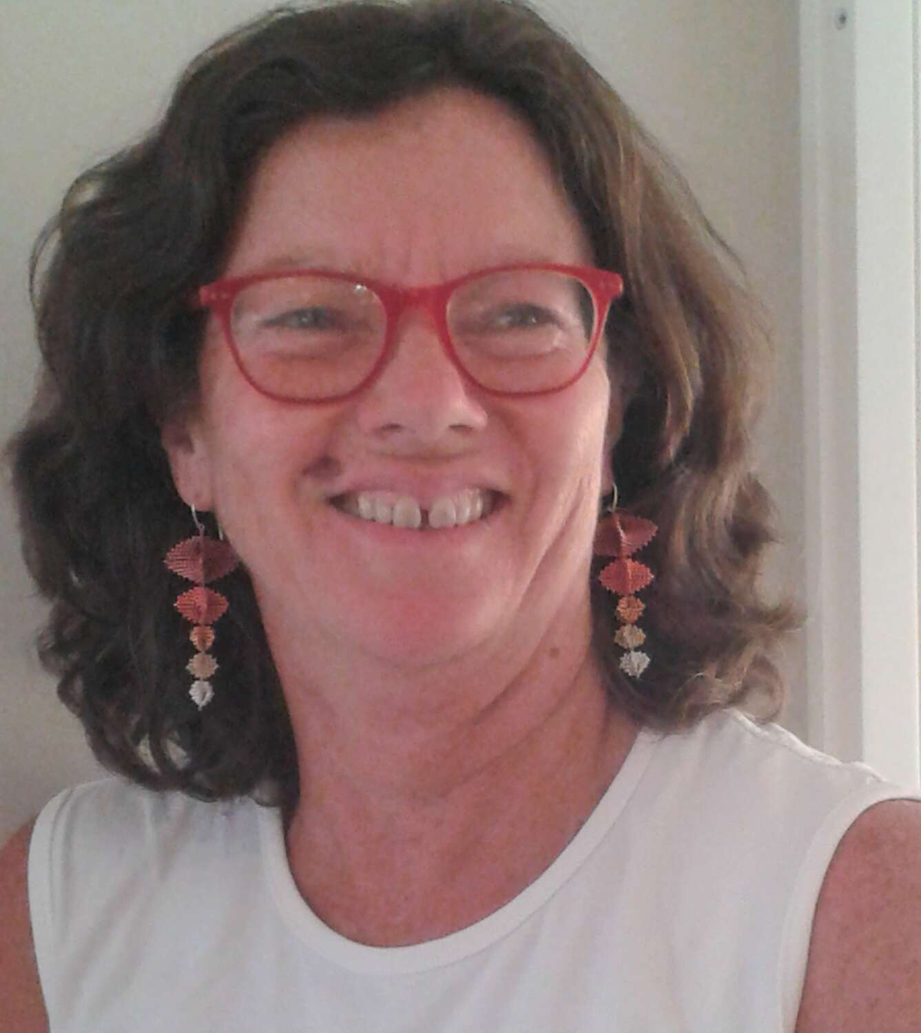 Head and shoulders photo of woman with red glasses.