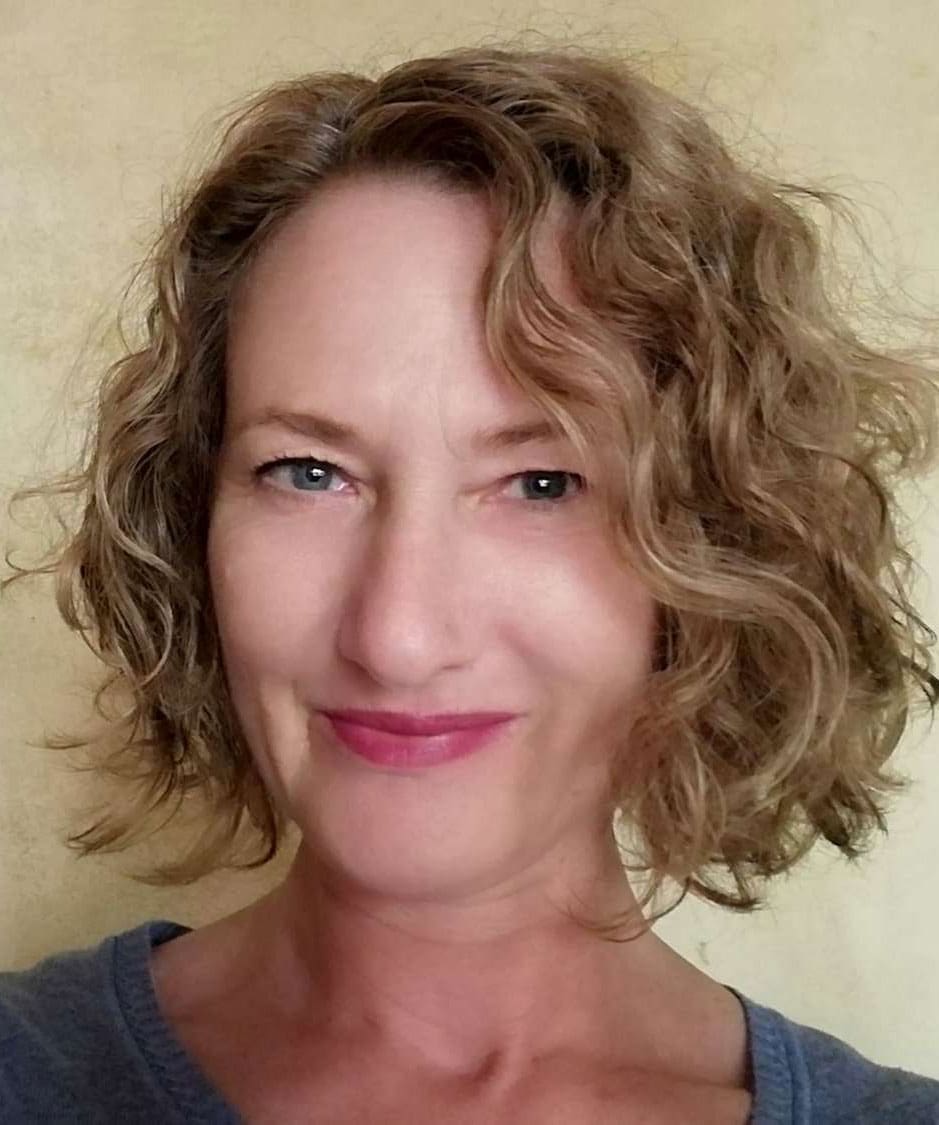 Headshot of woman with blond curly hair