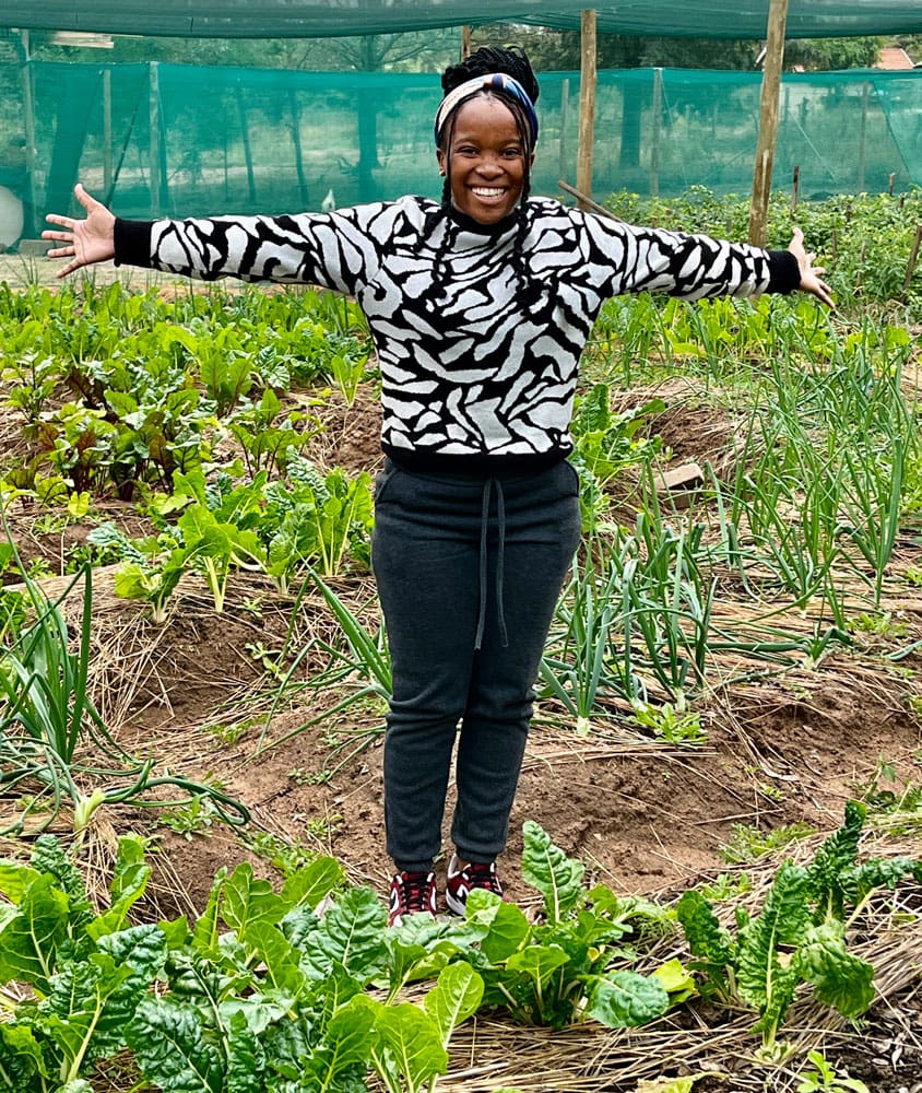 Quentan posing in her printed black and white shirt in the veggie garden