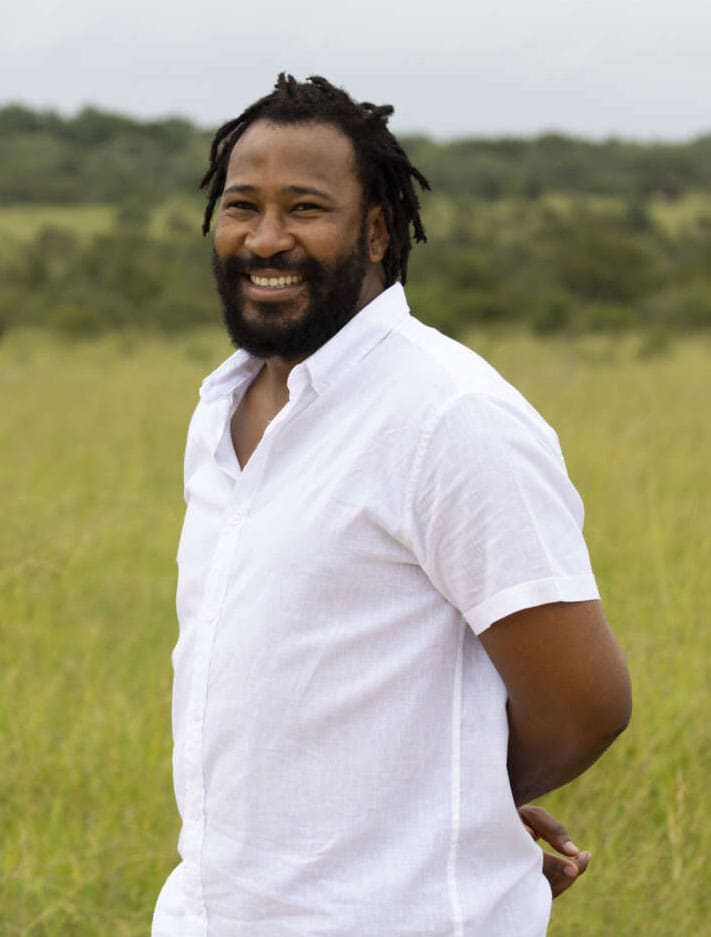Man with dreadlocks and white shirt.